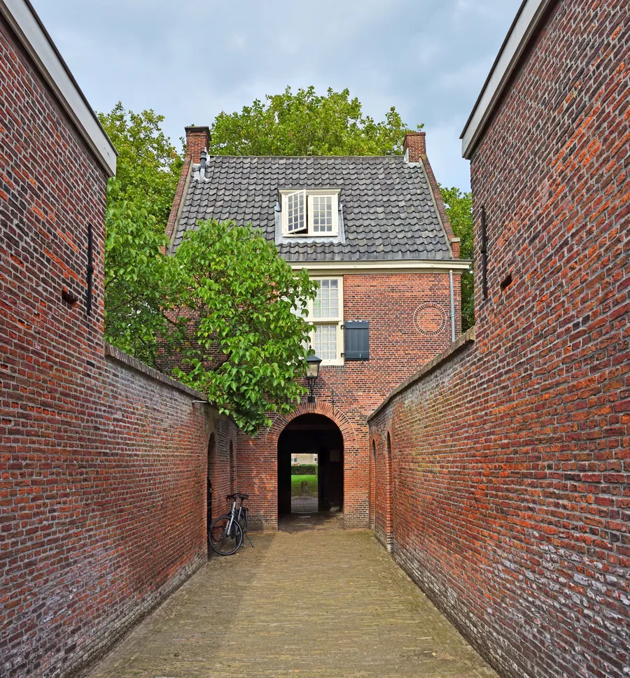 Een smalle doorgang naar het poortgebouw van het Hofje van Pauw.
